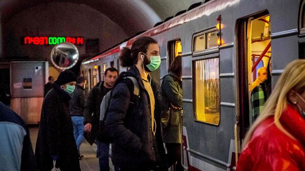 Молодые люди в масках садятся в поезд метро.  В Грузии борются с коронавирусом. В стране введен режим ЧП - Sputnik Грузия