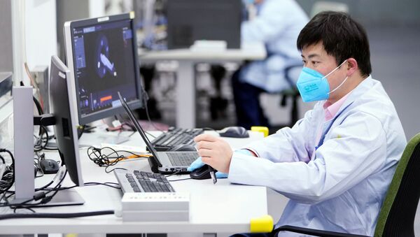 Работник в защитном костюме работает за компьютером в лаборатории Siemens в Шанхае, Китай - Sputnik Грузия