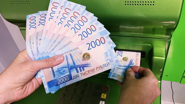 Клиент Сбербанка вносит наличные деньги в банкомат - Sputnik Грузия