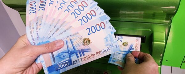 Клиент Сбербанка вносит наличные деньги в банкомат - Sputnik Грузия