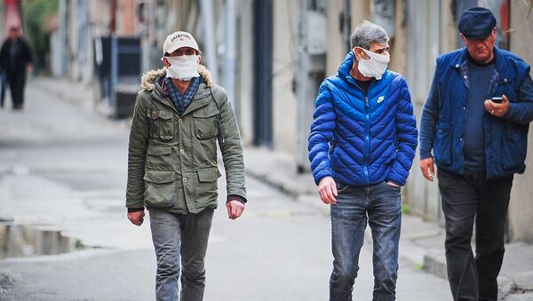 Пожилые мужчины в масках идут по улице в центре города. В Грузии борются с коронавирусом - Sputnik Грузия