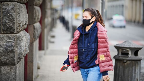 Молодая девушка в маске идет по улице в центре города. В Грузии борются с коронавирусом - Sputnik Грузия