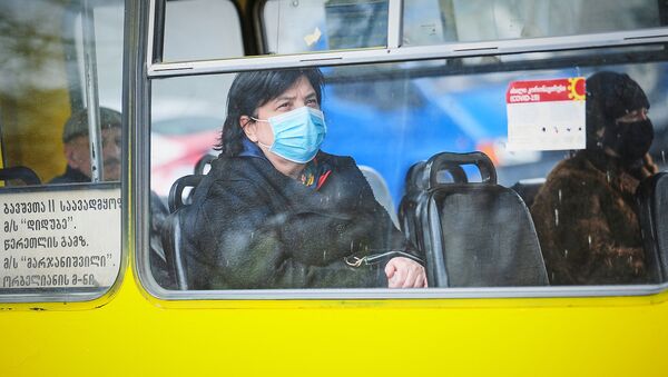 Пожилая женщина в маске едет в автобусе. В Грузии борются с коронавирусом, в стране введен режим ЧП - Sputnik Грузия