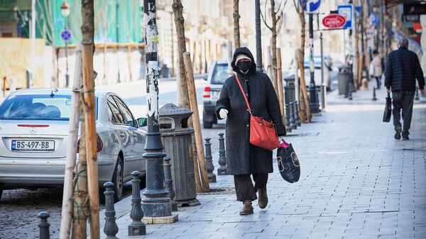 Пожилая женщина идет по улице в черной маске. В Грузии борются с коронавирусом - Sputnik Грузия