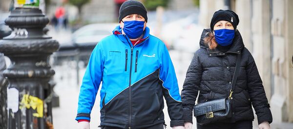 Семейная пара идет по улице в масках. В Грузии борются с коронавирусом - Sputnik Грузия