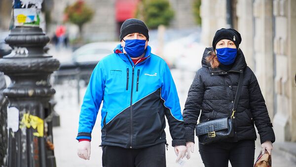 Семейная пара идет по улице в масках. В Грузии борются с коронавирусом - Sputnik Грузия