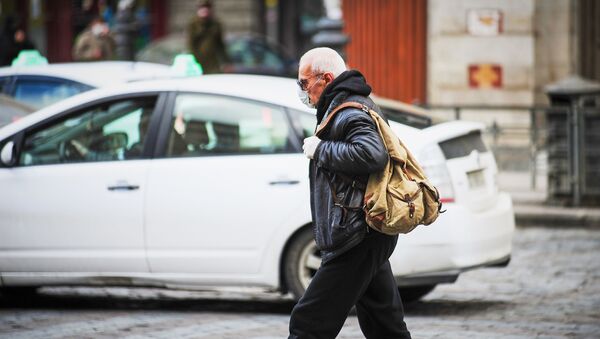 Пожилой мужчина в маске идет по улице. В Грузии борются с распространением коронавируса - Sputnik Грузия