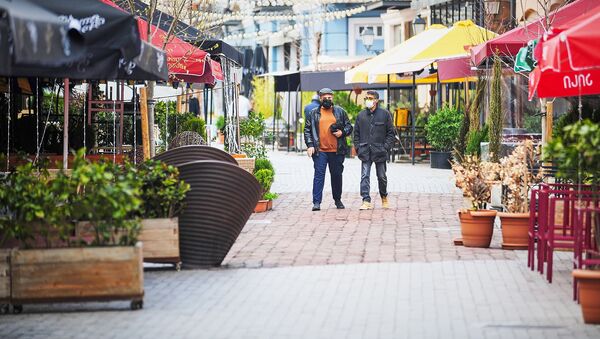Два туриста в масках стоят посередине квартала Новый Тифлис, где закрыты все кафе и рестораны. В Грузии борются с распространением коронавируса - Sputnik Грузия