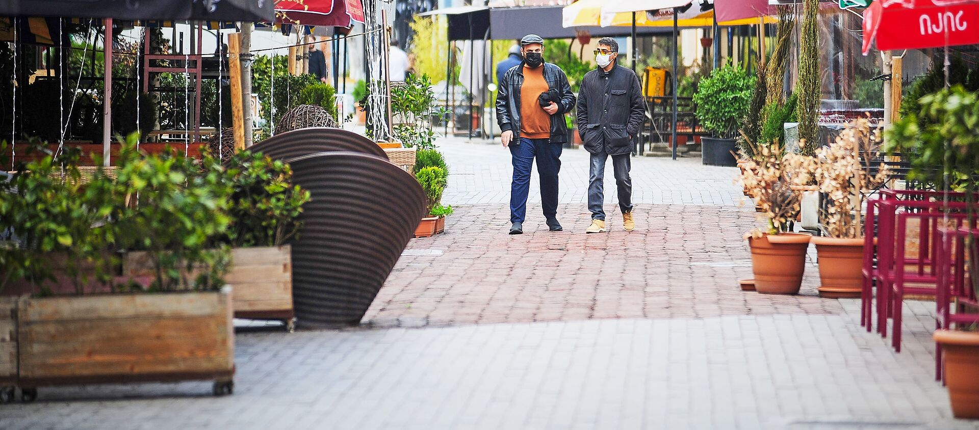 Два туриста в масках стоят посередине квартала Новый Тифлис, где закрыты все кафе и рестораны. В Грузии борются с распространением коронавируса - Sputnik Грузия, 1920, 22.04.2021