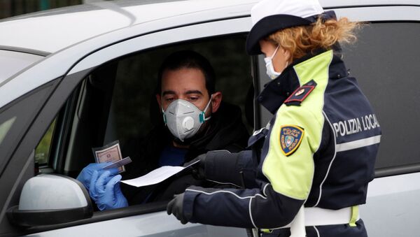 Сотрудник полиции проверяет людей на выезде с шоссе в Мольфетту. Ситуация в Италии в связи с коронавирусом - Sputnik Грузия