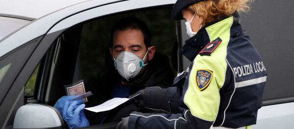 Сотрудник полиции проверяет людей на выезде с шоссе в Мольфетту. Ситуация в Италии в связи с коронавирусом Сотрудник полиции проверяет людей на выезде с шоссе в Мольфетту. Ситуация в Италии в связи с коронавирусом - Sputnik Грузия