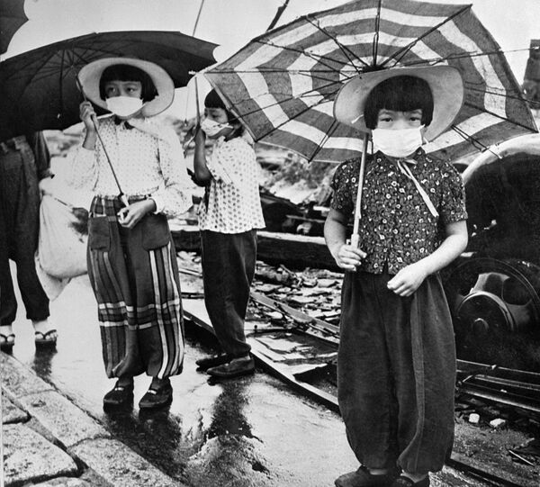 Дети в масках для защиты от облучения в разрушенной бомбардировкой Хиросиме в 1948 году - Sputnik Грузия