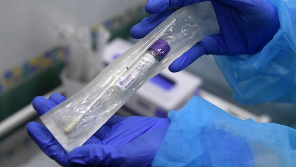 Пробирка с тестом на коронавирус в руках у сотрудницы в медицинской лаборатории - Sputnik Грузия