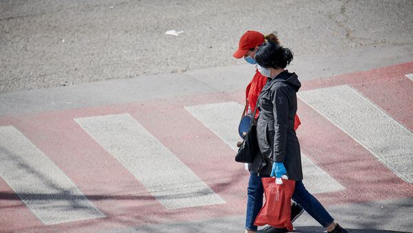 Девушки в масках идут по улице с покупками. В Грузии введен карантин и принимаются меры по борьбе с коронавирусом - Sputnik Грузия