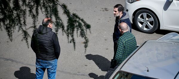 Группа из трех человек обсуждает на улице ситуацию в стране. В Грузии введен режим ЧП, карантин и комендантский час - Sputnik Грузия