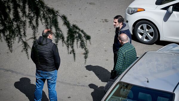 Группа из трех человек обсуждает на улице ситуацию в стране. В Грузии введен режим ЧП, карантин и комендантский час - Sputnik Грузия