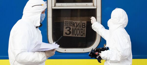Медики в костюмах биологической защиты у специального поезда №906/905 Киев - Москва - Киев, прибывшего на железнодорожный вокзал Киева - Sputnik Грузия