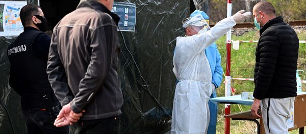 Медики измеряют температуру жителям в полевом госпитале на блокпосту на дороге между столицей Грузии и Мцхета - Sputnik Грузия