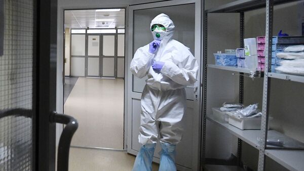 Сотрудник больницы надевает защитный костюм. Ситуация в связи с коронавирусом - Sputnik Грузия