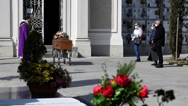 Похороны погибшего от коронавируса в Италии. Родственники стоят маленькой группой на дистанции от гроба - Sputnik Грузия