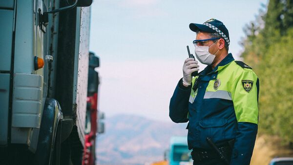 Сотрудник патрульной полиции проверяет документы у водителей на блокпосту в Марнеули - Sputnik Грузия