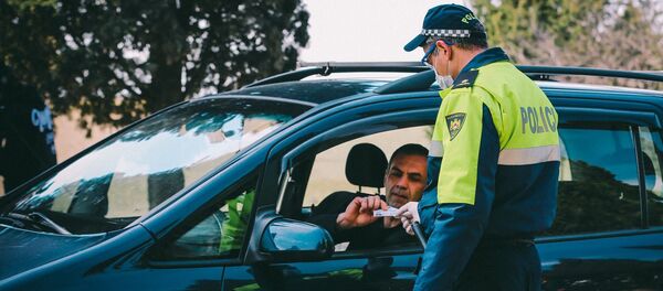 Сотрудник патрульной полиции проверяет документы у водителей на блокпосту в Марнеули - Sputnik Грузия