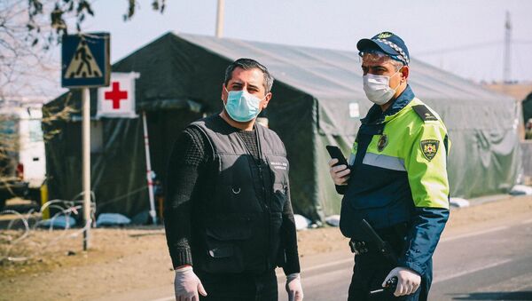 Сотрудники полиции во время карантина у полевого госпиталя на блокпосту - Sputnik Грузия