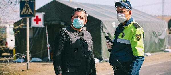 Сотрудники полиции во время карантина у полевого госпиталя на блокпосту - Sputnik Грузия