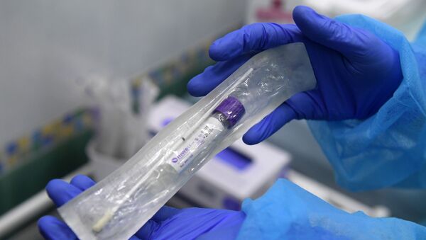 Пробирка с тестом на коронавирус в руках у сотрудницы в медицинской лаборатории в Москве - Sputnik Грузия