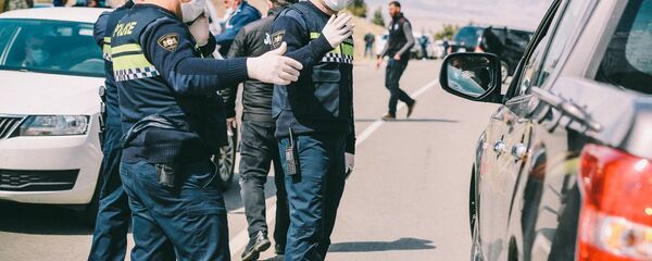 Сотрудники полиции досматривают машины на блокпосту - Sputnik Грузия