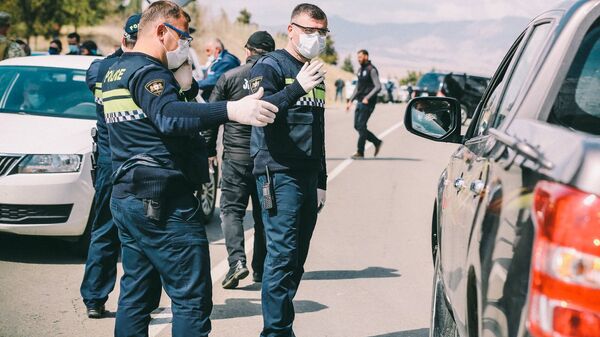 Сотрудники полиции досматривают машины на блокпосту - Sputnik Грузия