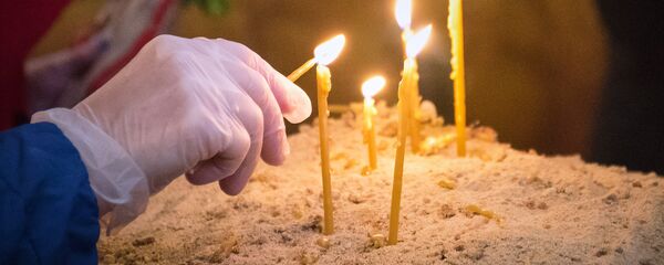 Вербное воскресенье в столице Грузии в условиях карантина. Верующие в перчатках зажигают свечи - Sputnik Грузия