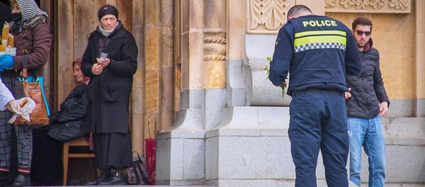 Вербное воскресенье в столице Грузии в условиях карантина. Полицейский молится у церкви - Sputnik Грузия