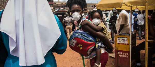 Мама с ребенком в защитных масках на автобусном вокзале в Кампале, Уганда Мама с ребенком в защитных масках на автобусном вокзале в Кампале, Уганда - Sputnik Грузия