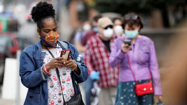 Прохожие в масках смотрят в мобильные устройства. Ситуация в США в связи с коронавирусом - Sputnik Грузия