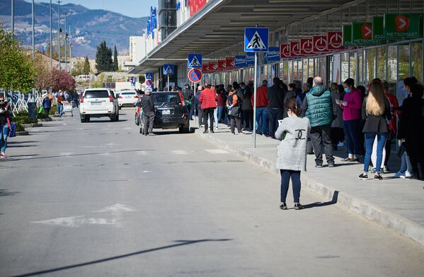 Чтобы успеть закупиться продуктами на праздники, сотни людей с утра в пятницу бросились в крупные супермаркеты - Sputnik Грузия