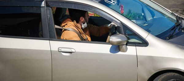 Водитель в маске и перчатках за рулем машины Водитель в маске и перчатках за рулем машины - Sputnik Грузия