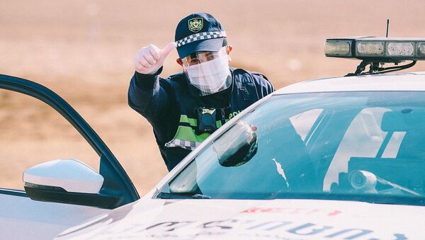 Полицейские в респираторах и лицевых щитках на блокпосту во время эпидемии коронавируса  - Sputnik Грузия