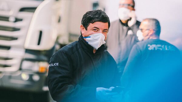 Полицейские на блокпосту во время эпидемии коронавируса проверяют автомашины - Sputnik Грузия