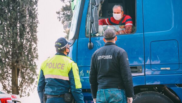 Полицейские на блокпосту в регионе во время эпидемии коронавируса проверяют автомашины - Sputnik Грузия
