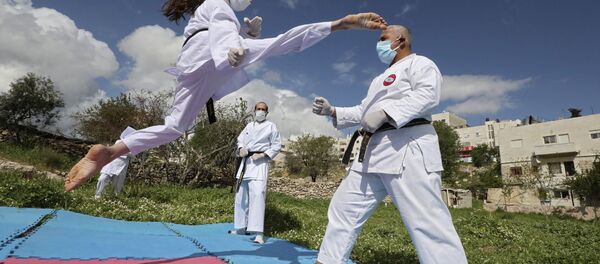 პალესტინელი ჩემპიონი კარატეში ვარჯიშის დროს მამასთან ერთად პალესტინელი ჩემპიონი კარატეში ვარჯიშის დროს მამასთან ერთად - Sputnik საქართველო