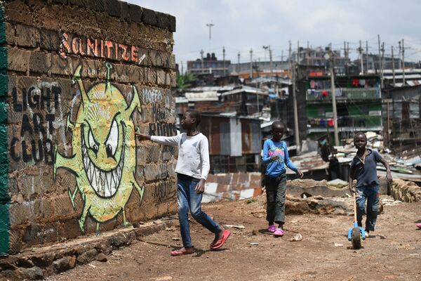 Подростки около граффити, предупреждающем людей о риске возникновения коронавируса COVID-19, в трущобах Найроби в Кении - Sputnik Грузия