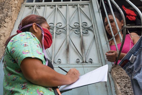 Медицинский работник во время обхода жителей для выявления случаев заболевания коронавирусом в фавелах Каракаса - Sputnik Грузия