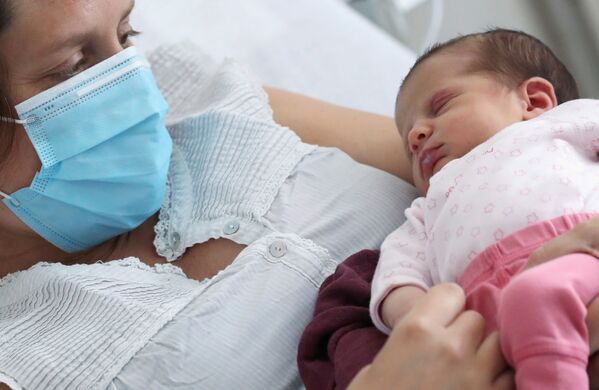 Амандин, у которой выявили коронавирус незадолго до родов, в защитной маске с новорожденной дочерью в больнице в Бельгии

 - Sputnik Грузия