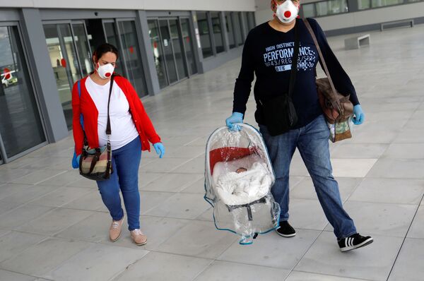 Супруги Нурия и Франсиско в защитных масках и с новорожденным сыном Хесусом покидают больницу в городе Ронда в Испании

 - Sputnik Грузия