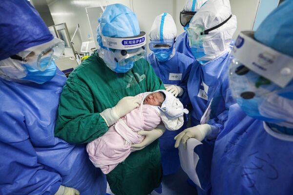მედმუშაკს ხელში უჭირავს ახალშობილი ბავშვი კორონავირუსით ინფიცირებული ორსულების განყოფილებაში უჰანის საავადმყოფოში - Sputnik საქართველო