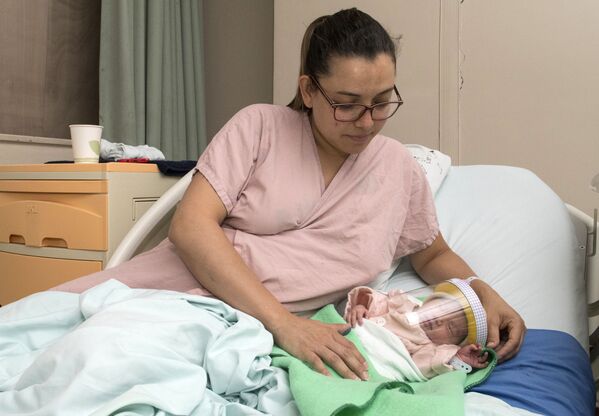 Женщина с новорожденным ребенком в защитной маске в отделении неонатологии мексиканской больницы в Сан-Хосе - Sputnik Грузия