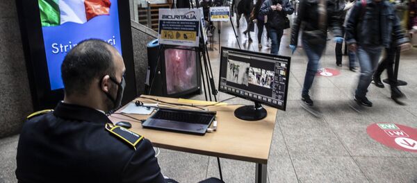 Охранник проверяет пассажиров на вокзале в Милане после этапного завершения карантина в Италии - Sputnik Грузия