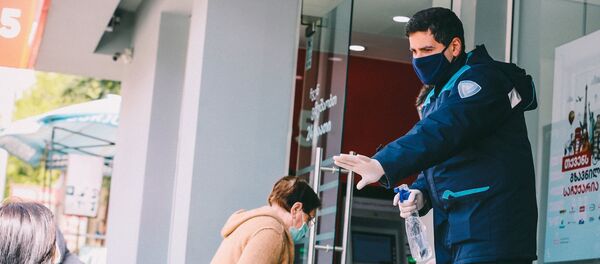 Полицейский у входа в магазин следит за порядком Полицейский у входа в магазин следит за порядком - Sputnik Грузия
