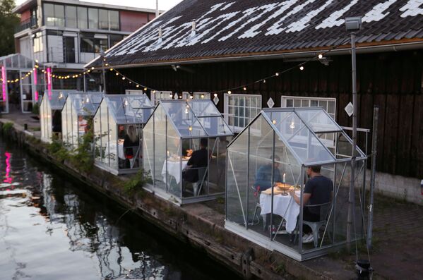 Владельцы ресторана ETEN в Амстердаме подошли к этому вопросу очень творчески и сделали антикоронавирусные кабинки - Sputnik Грузия